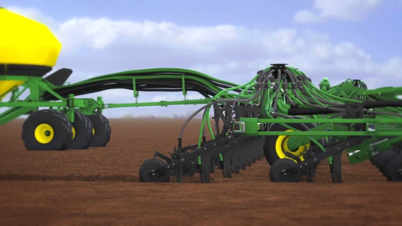 a row of green and black farm equipment